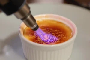 Torching sugar on crab brûlée